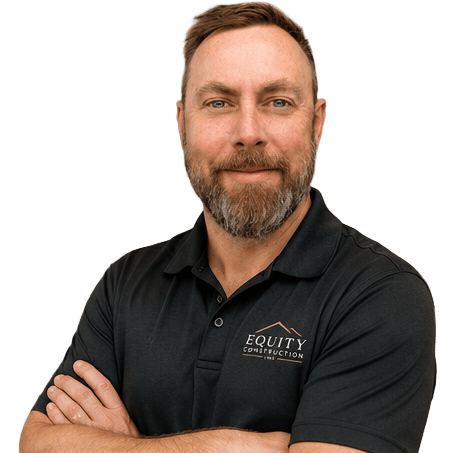 Professional headshot of Jay Alderson from Equity Construction Inc. smiling with arms crossed, wearing a black branded polo shirt against a transparent background.